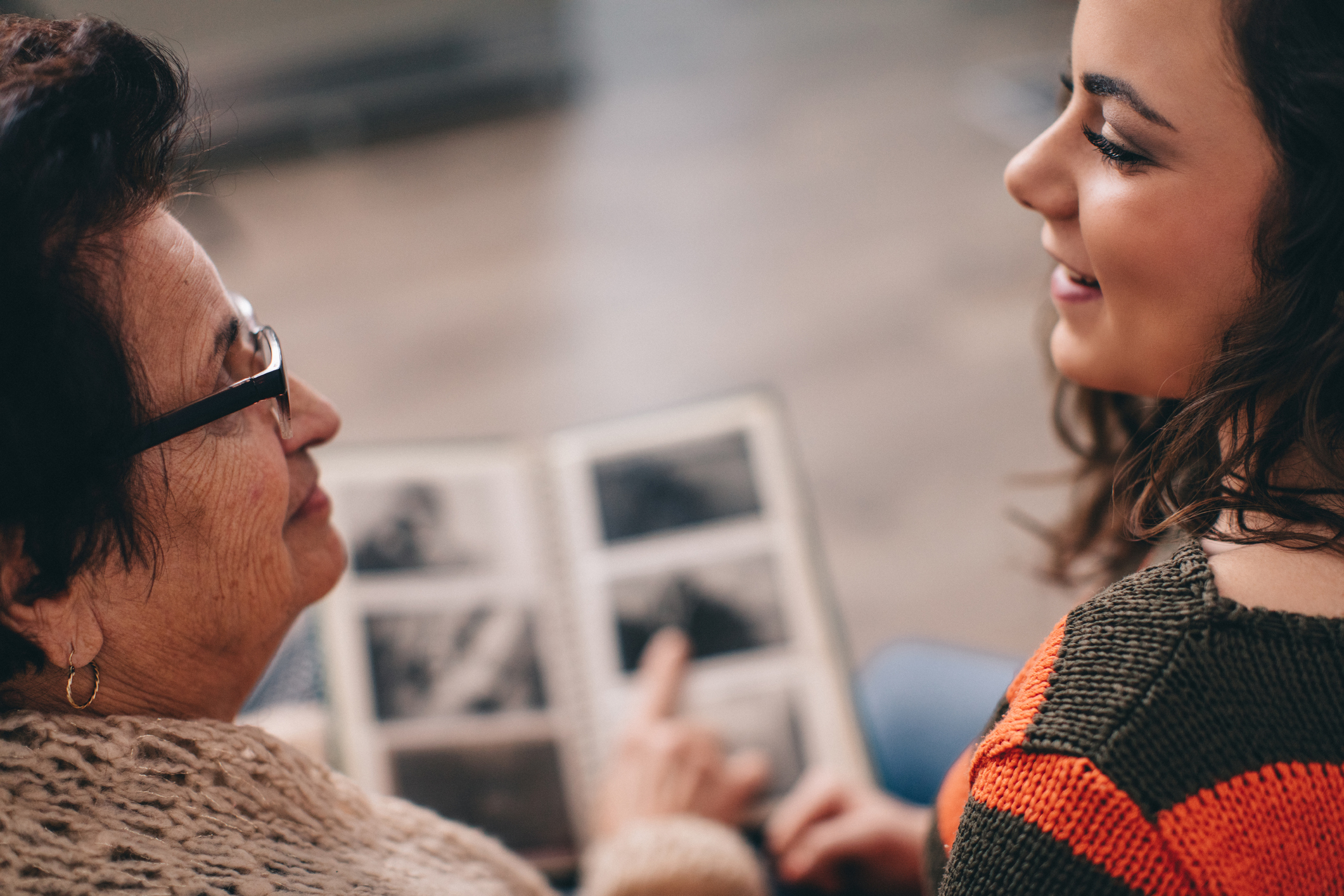 Senhora da terceira idade vê álbum de casamento do lado de sua neta. O teste de alzheimer ajuda a criar rotinas para aproveitar melhor — e ter mais qualidade de vida apesar da doença